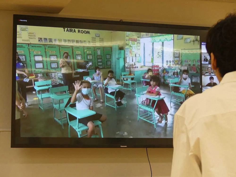 フィリピン・ダカイ小学校の生徒たちの元気な様子がスクリーンに映し出され、食い入るように見入るw－inds.の橘慶太