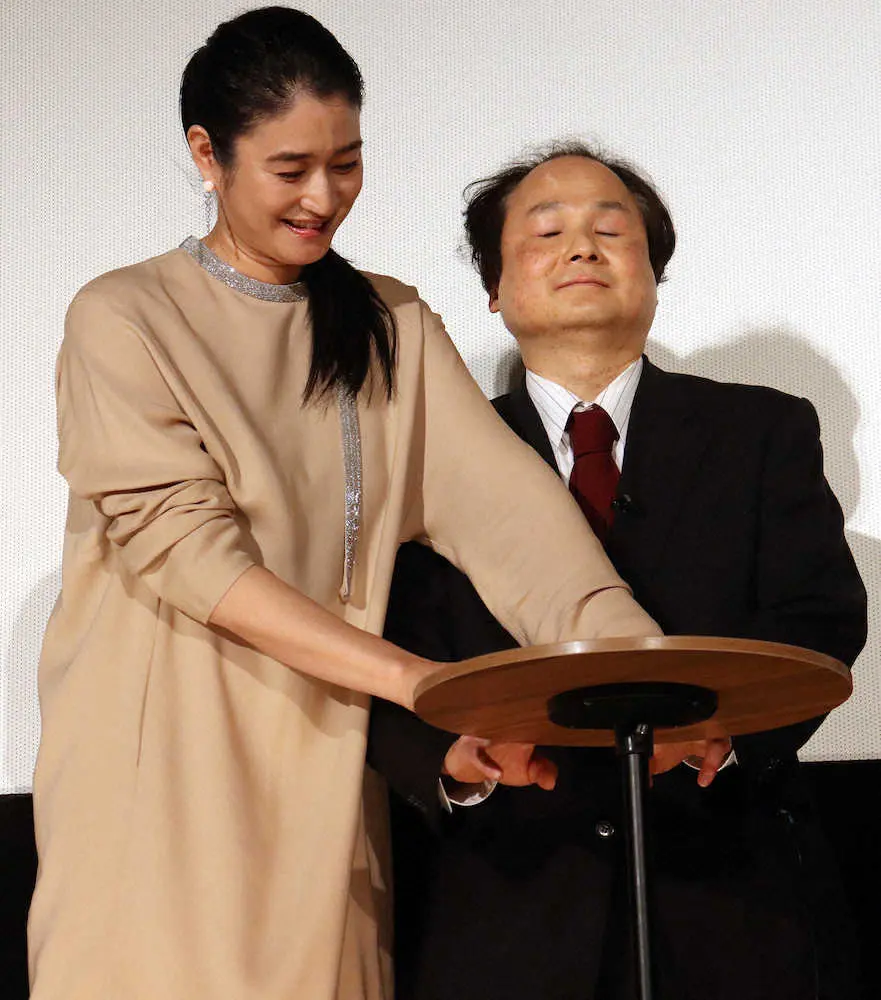 映画「桜色の風が咲く」の公開記念舞台あいさつで、福島氏に指点字で感謝を伝える小雪