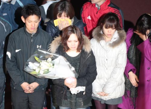 事故現場で花束を手に涙ぐむ同期の佐藤摩弥（中央）
