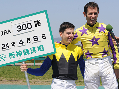 ＜阪神５Ｒ＞ＪＲＡ通算３００勝を達成したミルコ・デムーロ（右）は、弟・クリスチャンに記録ボードを持ってもらい笑顔