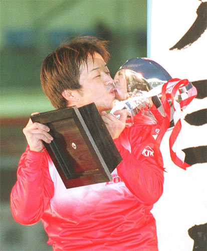 ００年、グランプリを初制覇しカップにキスをする児玉広志容疑者