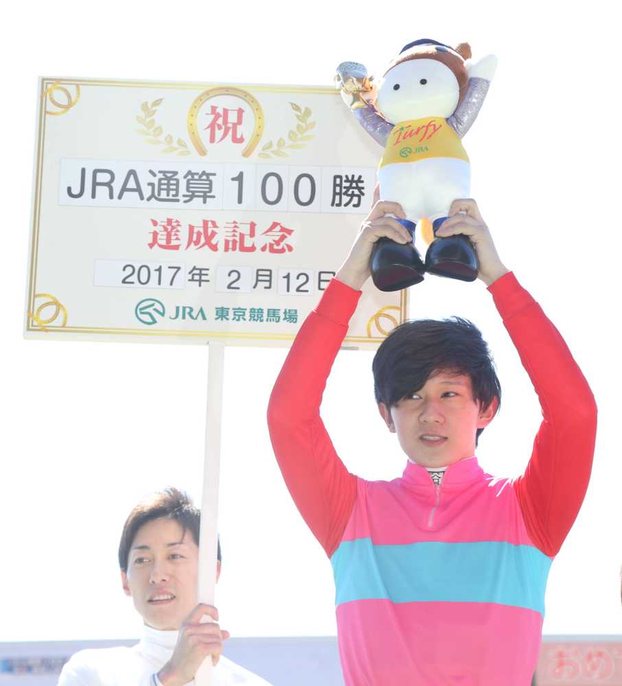 東京２Ｒ、ペイシャエヴァーでＪＲＡ通算１００勝を達成した石川は笑顔でターフィー人形を掲げる