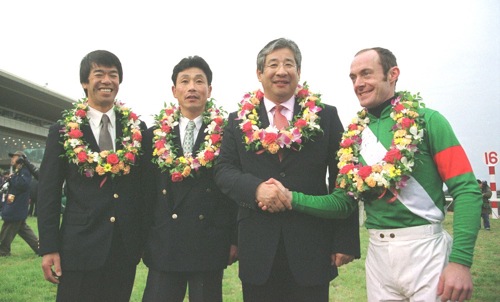 シンボリクリスエスで０２年の有馬記念を制覇し、笑顔を見せる藤沢和師（左端）とペリエ（右端）
