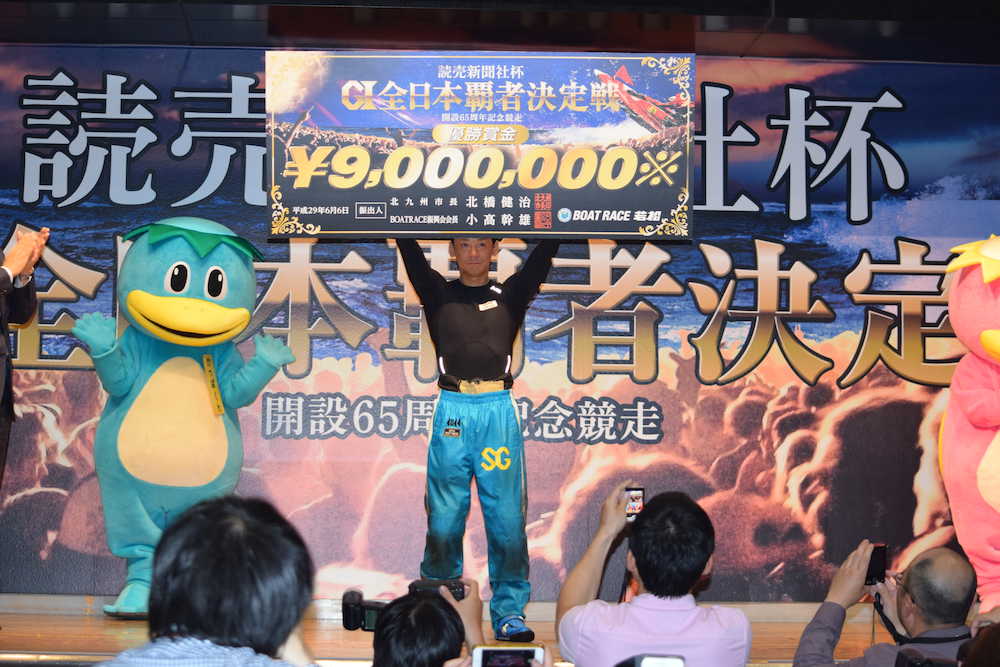 全日本覇者決定戦を制し賞金ボードを掲げる湯川浩司