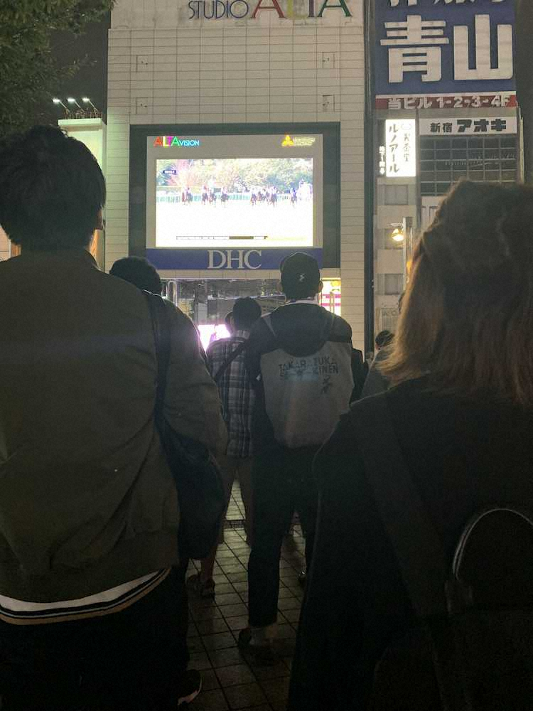 新宿アルタビジョン前で凱旋門賞PVを観戦する人々