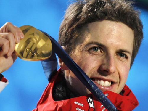 金メダルを手に笑顔を見せるスイスのシモン・アマン