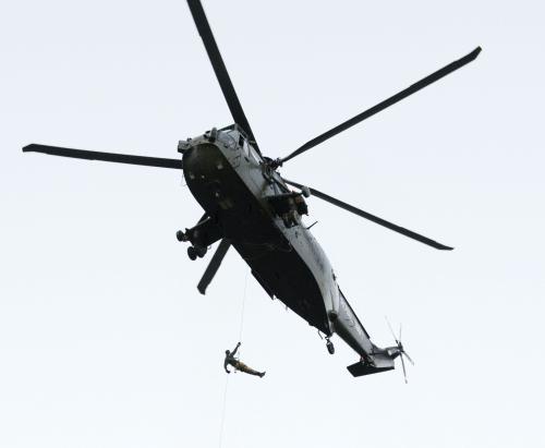 ヘリコプターでロンドン塔前に到着し、聖火がついたランタンを腰に提げて降下する海兵隊員
