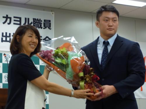 所属先の壮行会で小谷実可子監事（左）から花束を贈られる原沢久喜