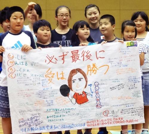 卓球女子リオ五輪代表の福原愛選手（右から４人目）に応援メッセージの旗を手渡した仙台市立東六郷小の子どもたち