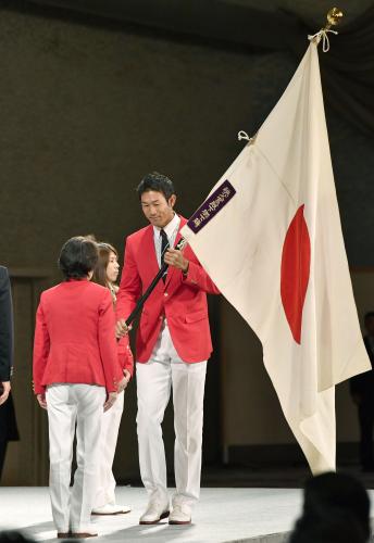 リオ五輪日本選手団の解団式で、橋本聖子団長（後ろ姿）に団旗を手渡す右代啓祐