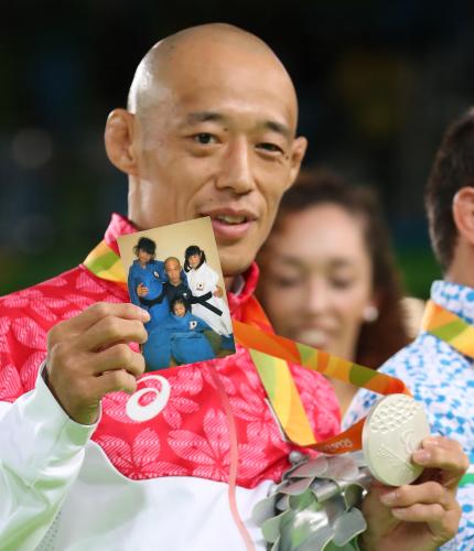 ＜リオパラリンピック柔道男子６０キロ級（視覚障がい）＞銀メダルを獲得し表彰台で愛娘たちの写真を披露する広瀬