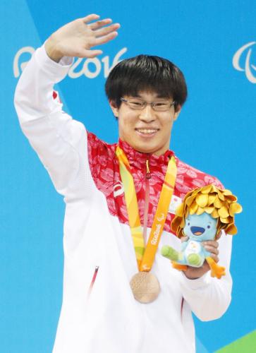 男子２００メートル個人メドレー（知的障害）で獲得した銅メダルを胸に、歓声に応える中島啓智