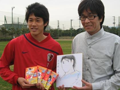 高橋陽一氏に似顔絵を描いてもらい笑顔の内田（左）
