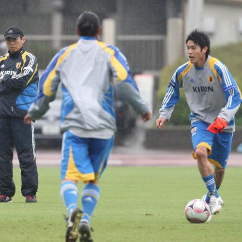 岡田監督（左）が見守る中、ミニゲームでボールをキープする内田（右）