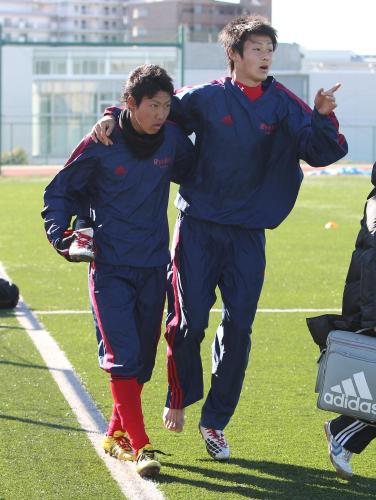 ＜高校サッカー練習＞練習中に右足を負傷した増田は吉田（左）の肩を借り、グランドを後にする