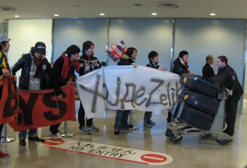成田空港で浦和サポーターから熱烈歓迎を受けるペトロビッチ新監督（右）