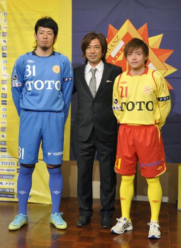 発表されたＪ２北九州の新しい胸スポンサーが入ったユニホーム。中央は三浦泰年新監督