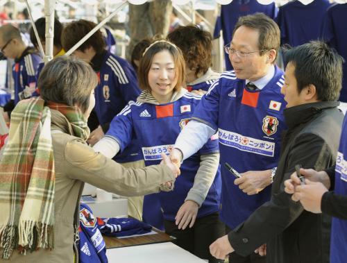 試合前、慈善試合のグッズ販売に協力する岡田武史前日本代表監督（右から２人目）ら