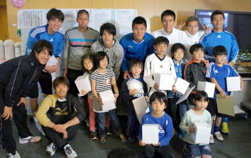 選手たちがプレゼントしたサッカーボールを手に記念撮影する子どもたち（日本プロサッカー選手会提供）