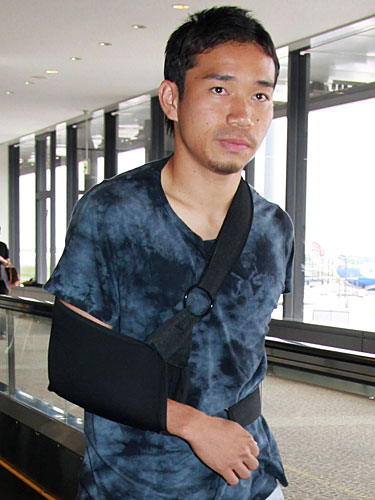 右肩をギプスで固定した状態で成田空港に到着した長友
