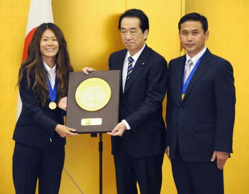 国民栄誉賞を受賞し、菅首相から記念の盾を受け取る「なでしこジャパン」の沢穂希選手（左）。右は佐々木則夫監督
