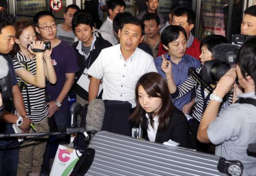 中国山東省済南に到着し、報道陣に囲まれるサッカー女子日本代表の佐々木監督（中央）