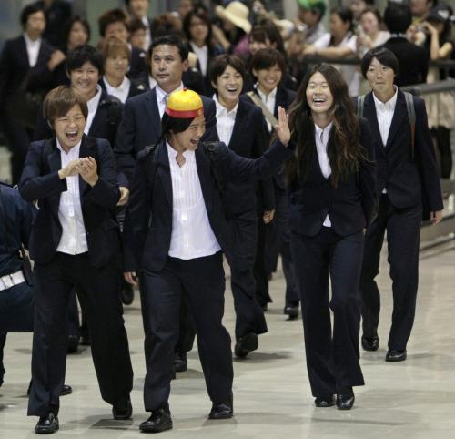 中国から帰国し、出迎えのファンらに笑顔を見せる（手前左から）宮間、大野、沢らサッカー女子日本代表の選手たち。大野の後ろは佐々木監督