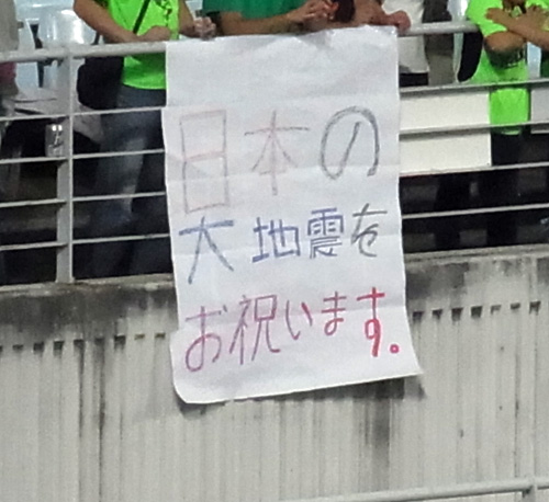全北側のスタンドに掲げられた「日本の大地震をお祝い（し）ます」と書かれた横断幕