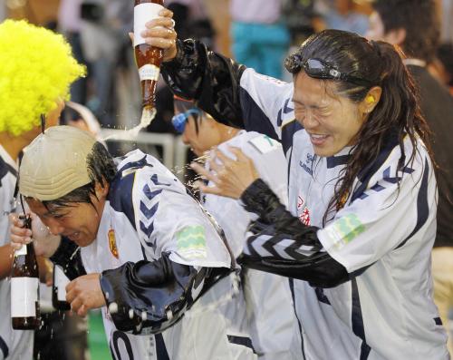 リーグ初優勝を決め、祝勝会で大野（左）と飲料を掛け合って喜ぶＩＮＡＣ神戸・沢