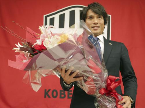 引退表明の記者会見を終え、花束を手に笑顔を見せるＪ１神戸の宮本恒靖