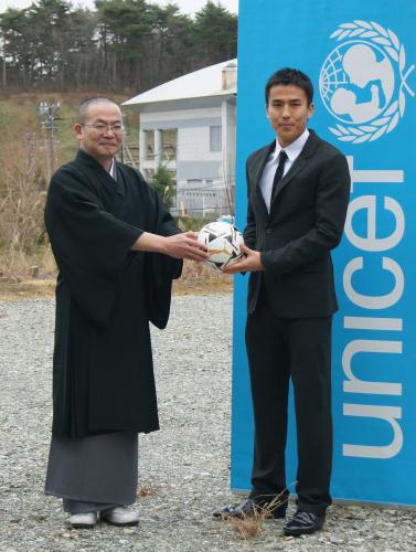 私立あさひ幼稚園の小島孝尋園長（左）に記念のサッカーボールを手渡す長谷部誠選手