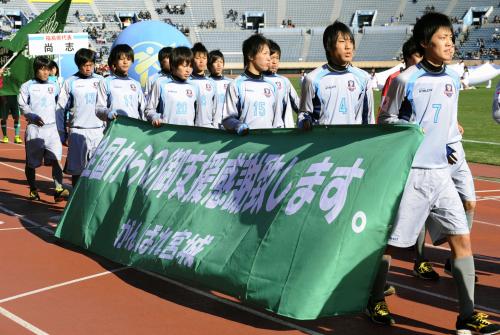 第90回全国高校サッカー選手権の開会式で、東日本大震災の復興支援に感謝する横断幕を手に入場行進する宮城県代表の聖和学園イレブン