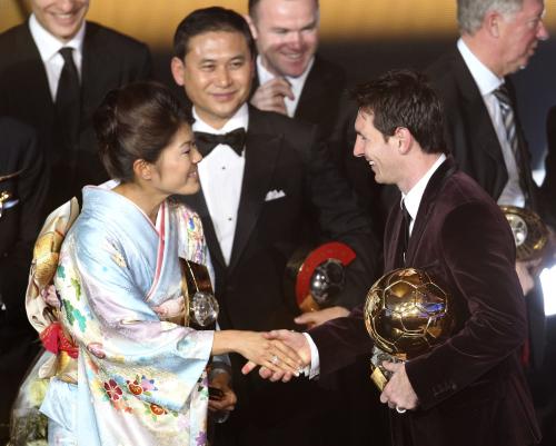 国際サッカー連盟の世界年間最優秀選手に選ばれ、アルゼンチン代表のメッシ（右）と握手する日本代表の沢穂希選手。中央左は佐々木則夫監督