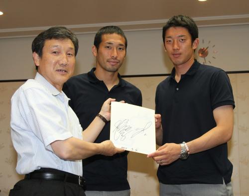 小平市役所を表敬訪問したＦＣ東京の徳永（中）と権田（右）が小林正則市長（左）にサインをプレゼントする
