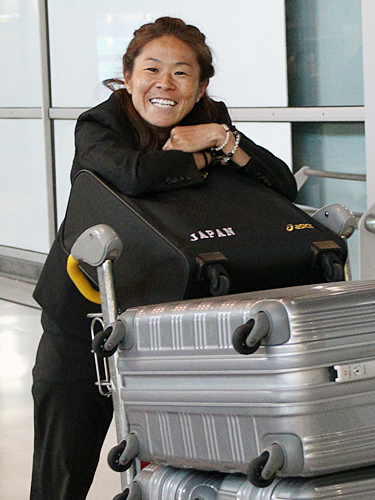 パリに到着した沢はスーツケースを押しながら笑顔を見せる