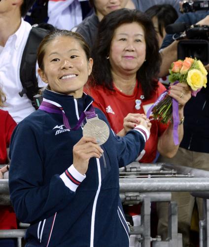 メダルを母満寿子さん（右）に見せ笑顔の沢