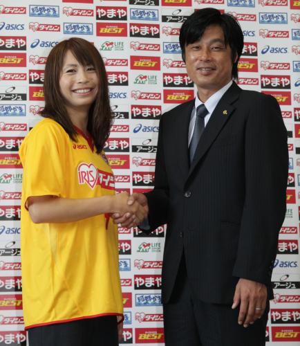 仙台レディースのユニホームを着た鮫島が千葉監督（右）と笑顔で握手する