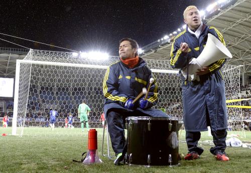 慈善試合「チャリティーサッカー２０１２」で、試合中に太鼓をたたくインテル・ミラノの長友佑都。右はフィテッセの安田理大