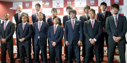 写真撮影に臨む安達監督（前列左から３人目）、和田副社長（前列右から３人目）、和田副社長の三男の倫季（後列右から２人目）ら