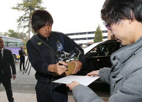 スパイクを手に宿舎に到着した遠藤は、ファンにサインする