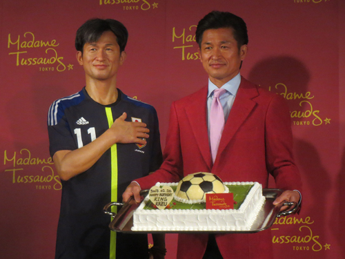 サッカーボール型の誕生ケーキをプレゼントされたカズ、左は等身大フィギュア