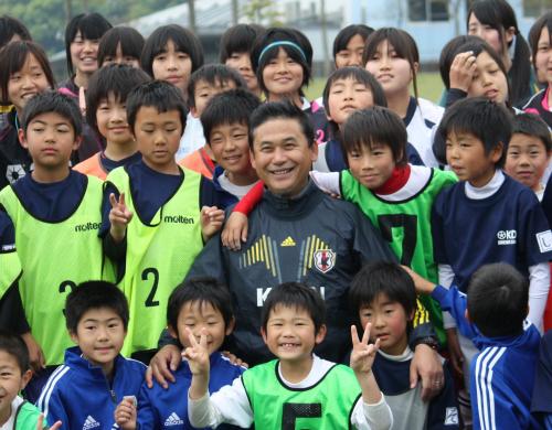 鳥栖市でのサッカー教室で参加したサッカーキッズ、高校生と記念写真に収まるなでしこジャパンの佐々木監督