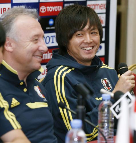 記者会見で笑顔を見せるサッカー日本代表の遠藤（右）とザッケローニ監督＝10日、ドーハ