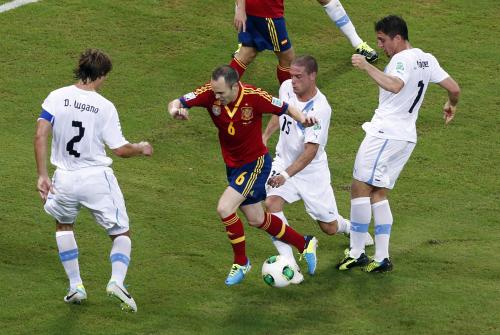 ウルグアイ代表ＤＦ陣に囲まれながらもボールをキープするスペイン代表ＭＦイニエスタ（中央左）
