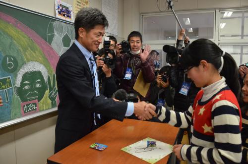 子どもたち１人ひとりにサインし、握手する横浜ＦＣのカズ