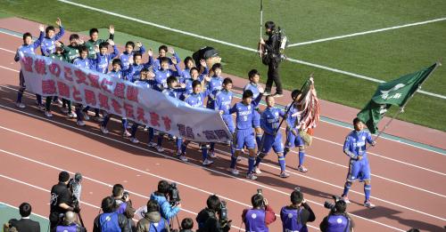 復興支援に感謝する横断幕を手に、入場行進する福島県代表の富岡イレブン