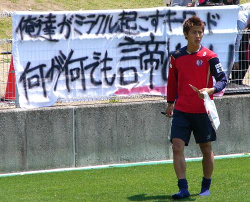 サポーターが掲げた「何が何でも諦めへん」の横断幕の前を歩くＣ大阪ＦＷ柿谷