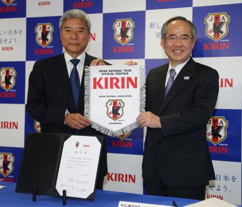 大仁日本サッカー協会会長（左）からエンブレムを受け取るキリンの磯崎社長