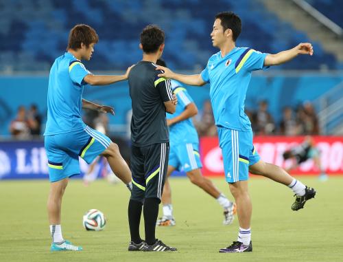 ＜日本代表練習＞コーチの肩をつかみ、足を伸ばす吉田（右）
