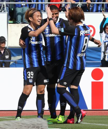 ＜Ｇ大阪・新潟＞後半３分、宇佐美（左）はリーグ５戦連発のゴールを決め、笑顔でハイタッチ